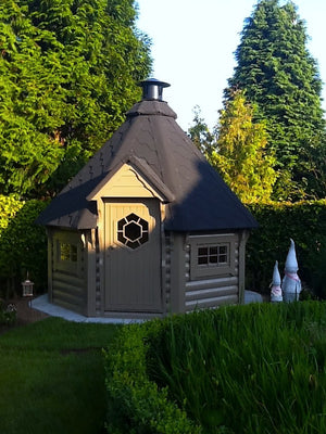 finnish bbq hut placed in the beautiful backyard garden